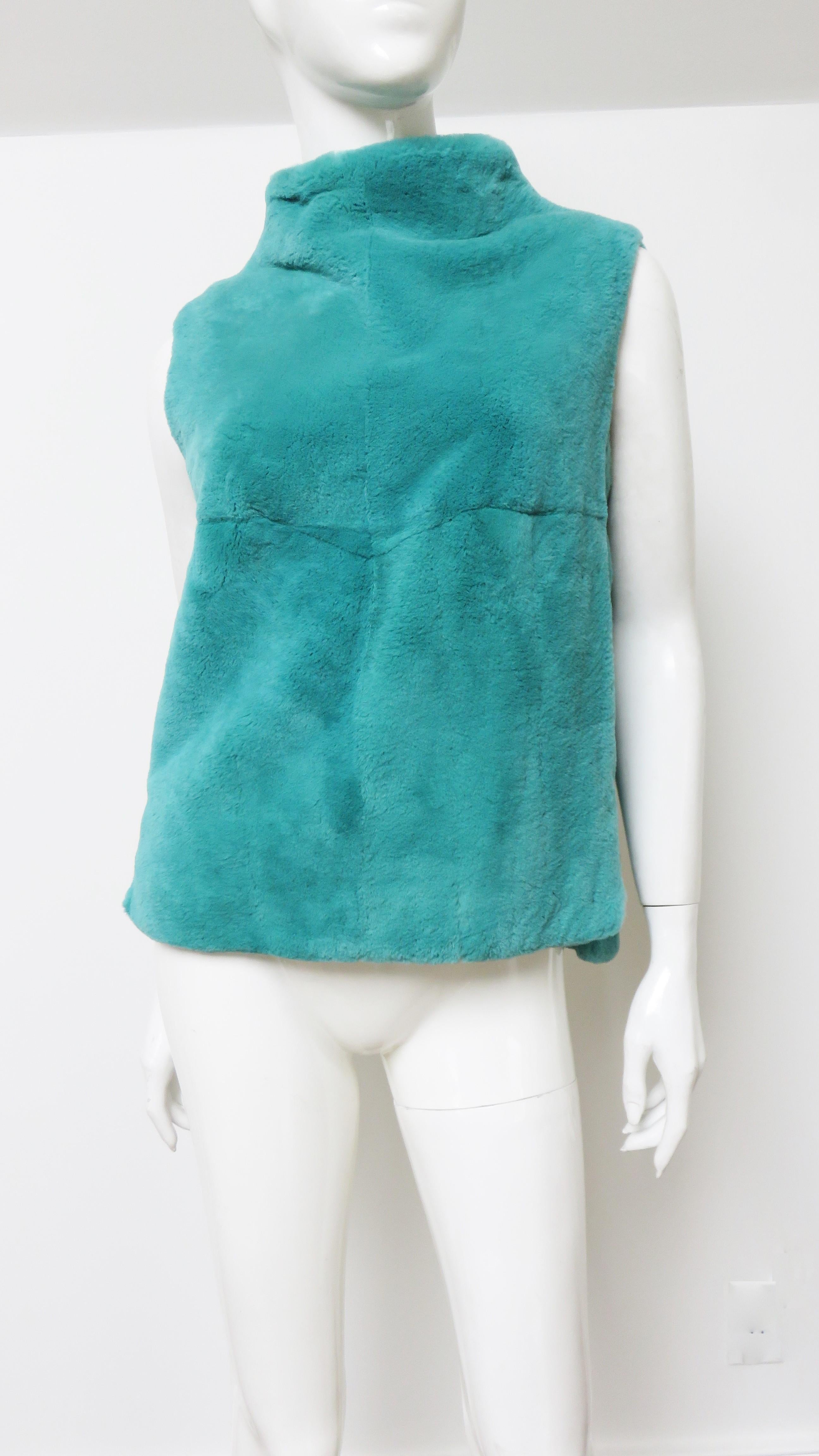 A gorgeous sheared fur vest by Coach. It is sleeveless with a stand up collar and side seam pockets. The back is 1 1/2