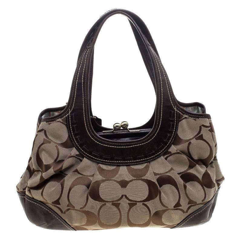 Handcrafted from signature canvas and leather, this Coach bag has a fabric interior divided by a kiss lock compartment. Use the two shoulder handles to parade this beautiful bag.

Includes: The Luxury Closet Packaging

