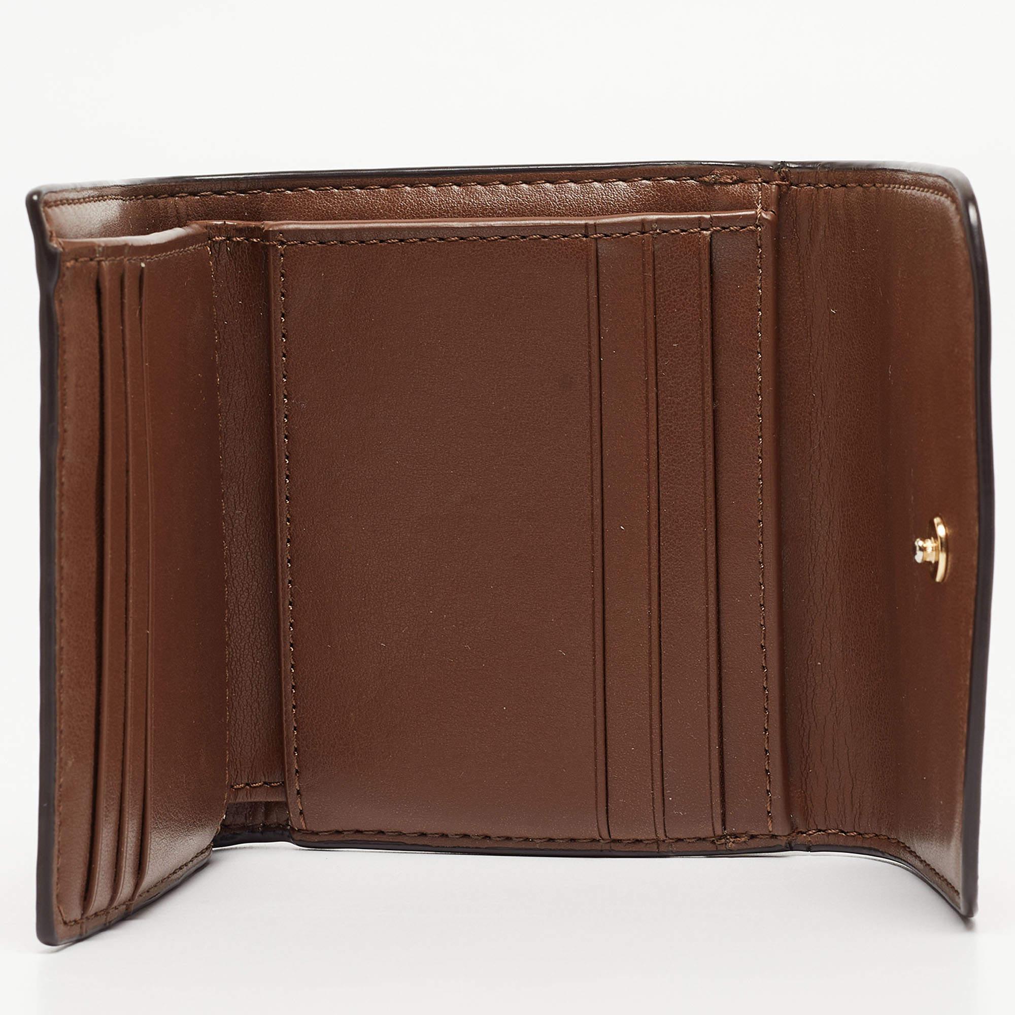 Stylish wallets are a must have! This compact wallet from the house of Coach comes with a logo in gold-tone at the front flap. Crafted from signature coated canvas and leather, the wallet is versatile with multiple card slots and slip compartments