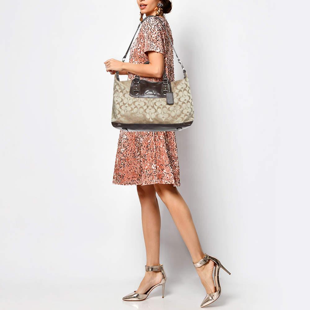 This Ashley bag from Coach will never fail to delight you. It comes crafted from the brand's signature fabric and patent leather and features dual top handles. It flaunts the brand logo on the front and opens to a spacious satin lined interior