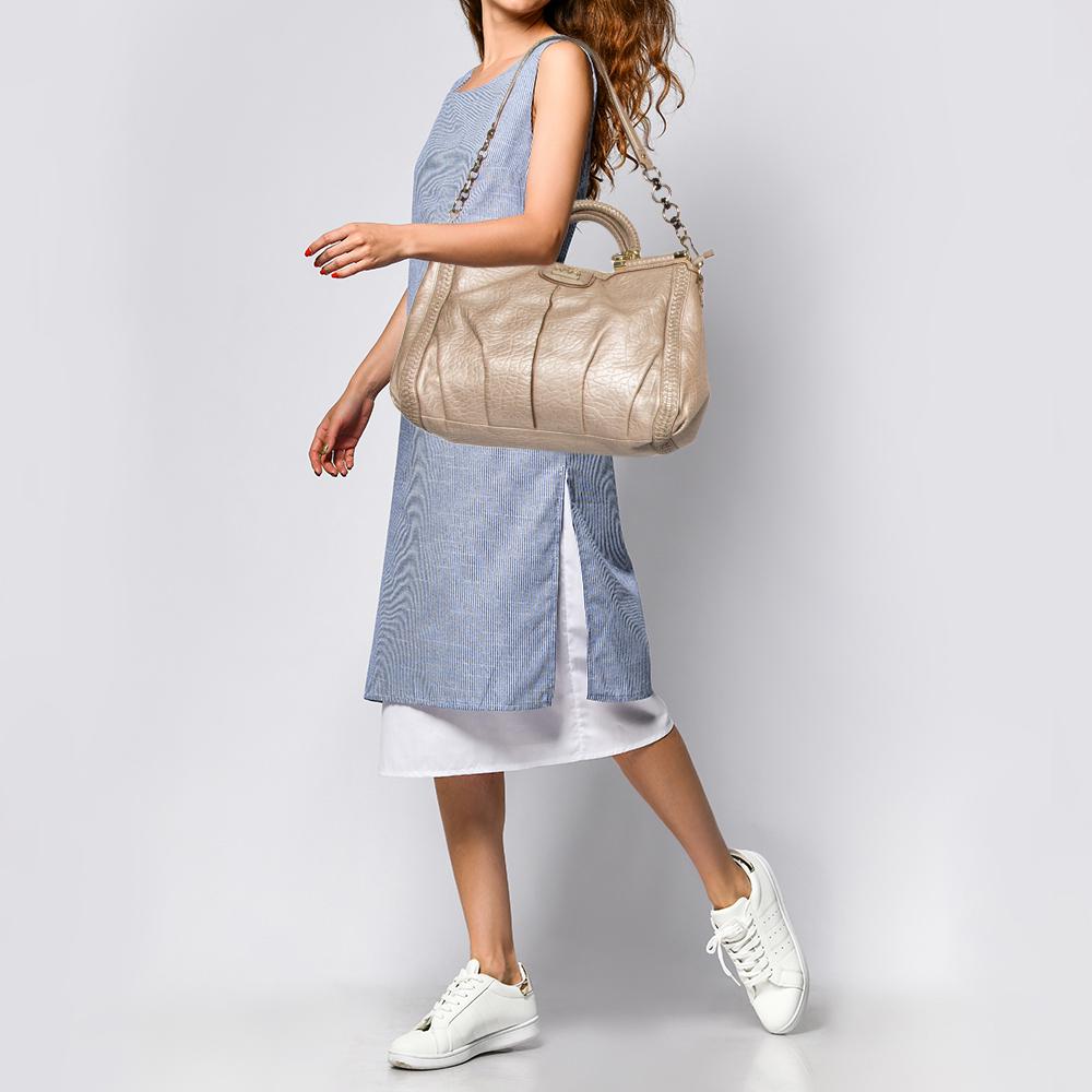 Crafted from leather, this Dowel Caroline tote is stylish and functional. It carries a beige exterior, gold-tone hardware, and a satin-lined interior. The tote is equipped with two handles and a shoulder strap.

Includes:  Strap