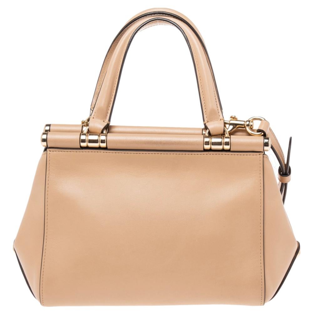 With this Grace 20 satchel from the House of Coach, you can store your daily necessities with ease and style. It is made from beige leather on the exterior and flaunts dual handles, a fabric-lined interior, and gold-toned hardware. Grab this classy