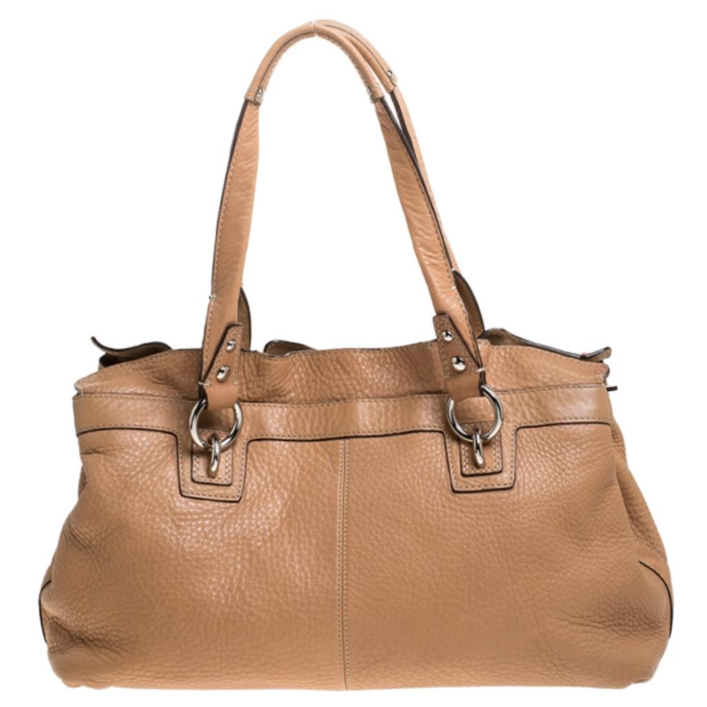 A fine mix of charm and style, this leather bag is sure to make you glad. This bag has a satin lining offering enough storage for everyday essentials. Lifted by two top handles, this Coach tote boasts of style and luxury. Every fashion connoisseur