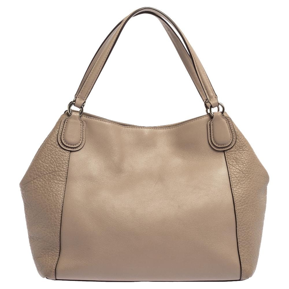 This Coach satchel will instantly elevate the look of any outfit. This bag is made of quality leather in a classy style. Lined with fabric, the interior of this bag is as enduring as the exterior. Boasting of an impressive beige hue and the brand