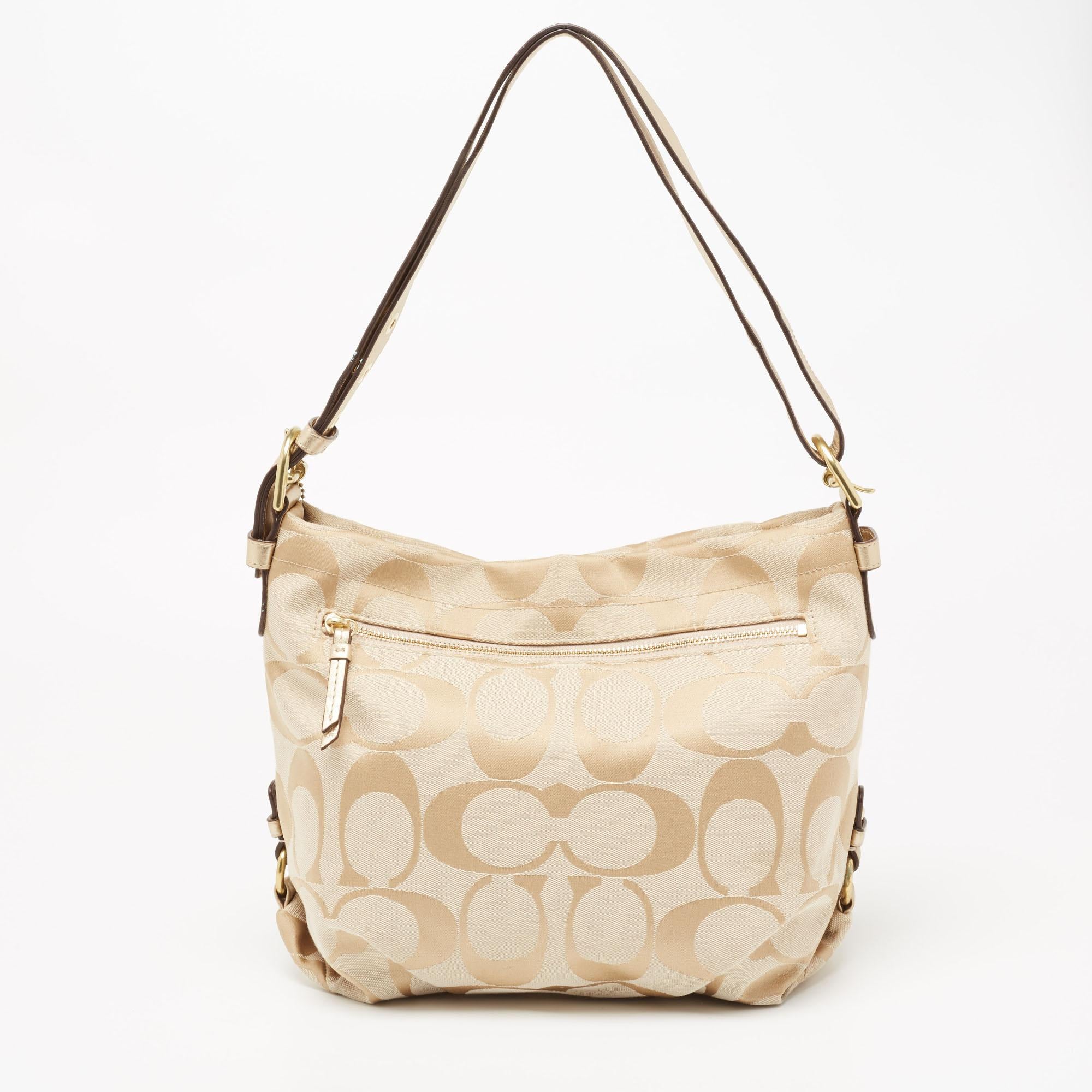 Add this elegant hobo from Coach to your collection. Crafted from signature canvas, the bag is enhanced with leather trims and gold-tone hardware. It is further equipped with a single adjustable handle and a fabric-lined interior that is secured by