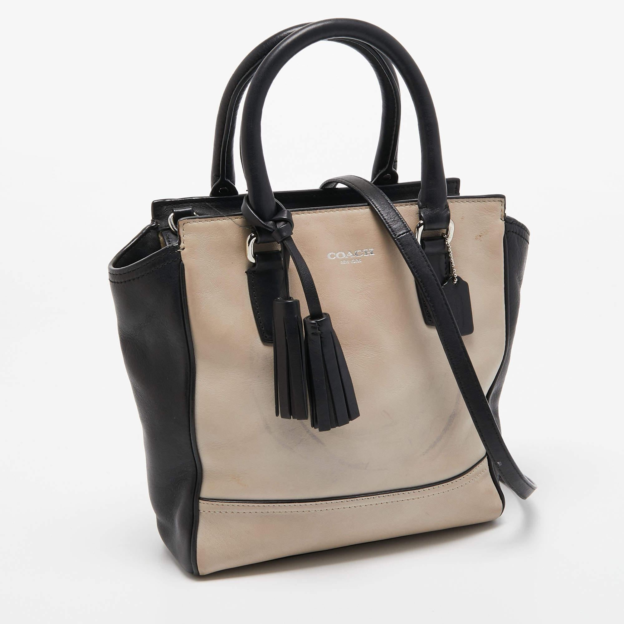 Elegant style and utility combine to form this bag from Coach. Crafted using leather the designer tote features a front brand logo a lined interior two handles and a shoulder strap. Tassel charms complete it.