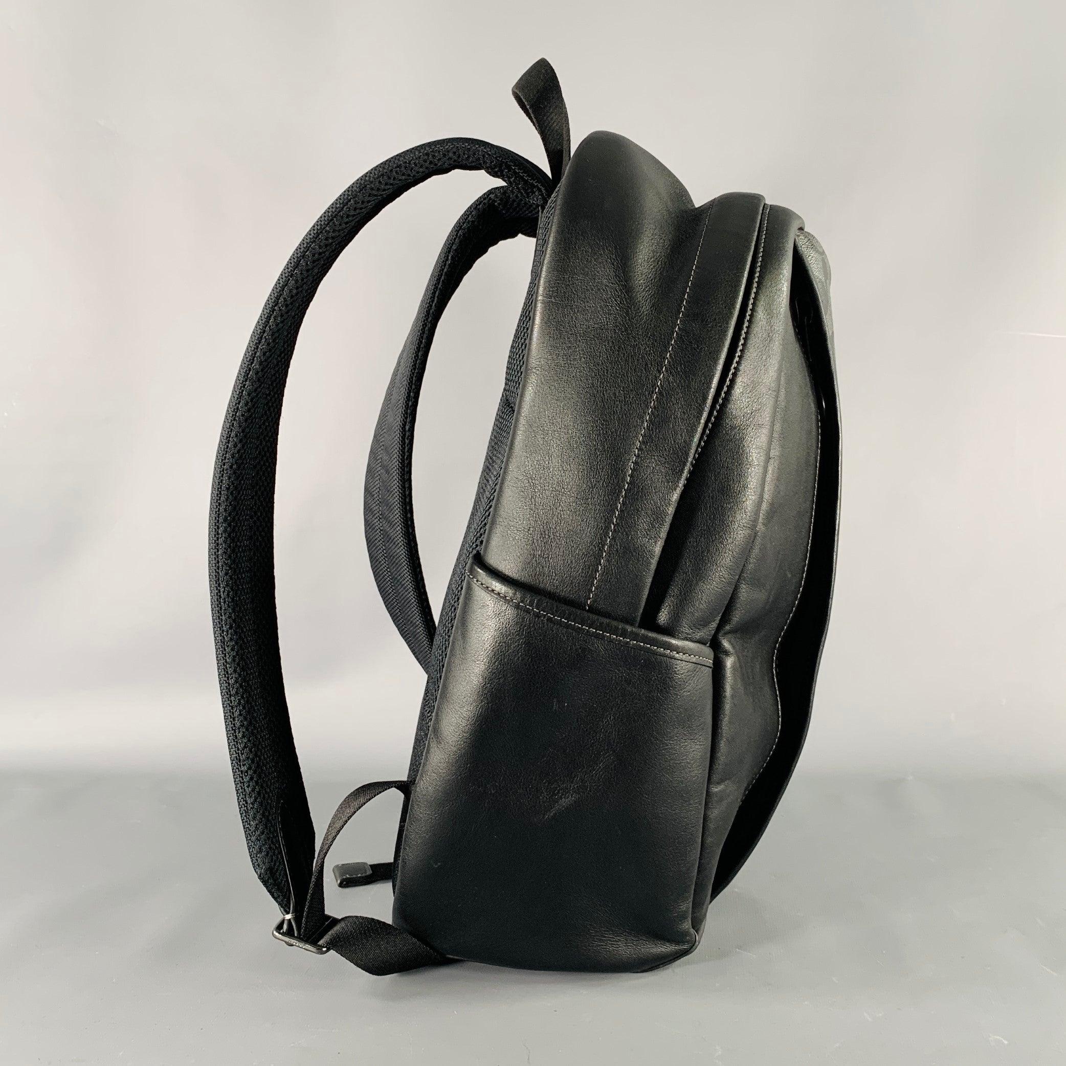 COACH backpack
in a black and grey leather featuring monogram print, spacious interior with padded tech pocket, and zip closure.Very Good Pre-Owned Condition. 

Marked:   H2361-CM024 

Measurements: 
  Length: 8.25 inches Width: 6 inches Height: 17