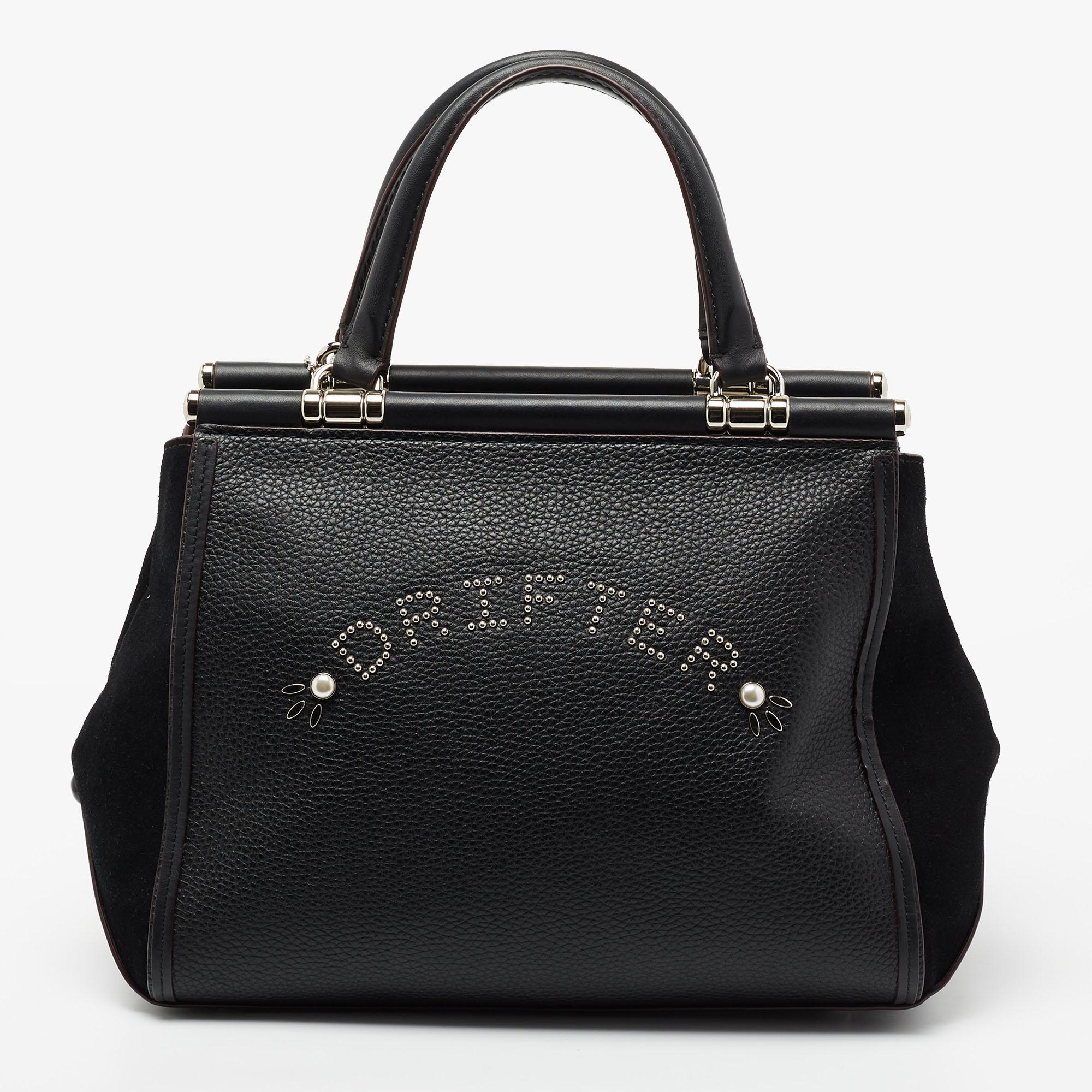 Crafted from leather and suede, this Coach Drifter satchel is gorgeous and functional. It carries a black exterior enhanced with studded embellishments and has a spacious interior sized to carry your essentials. The artistic bag is equipped with