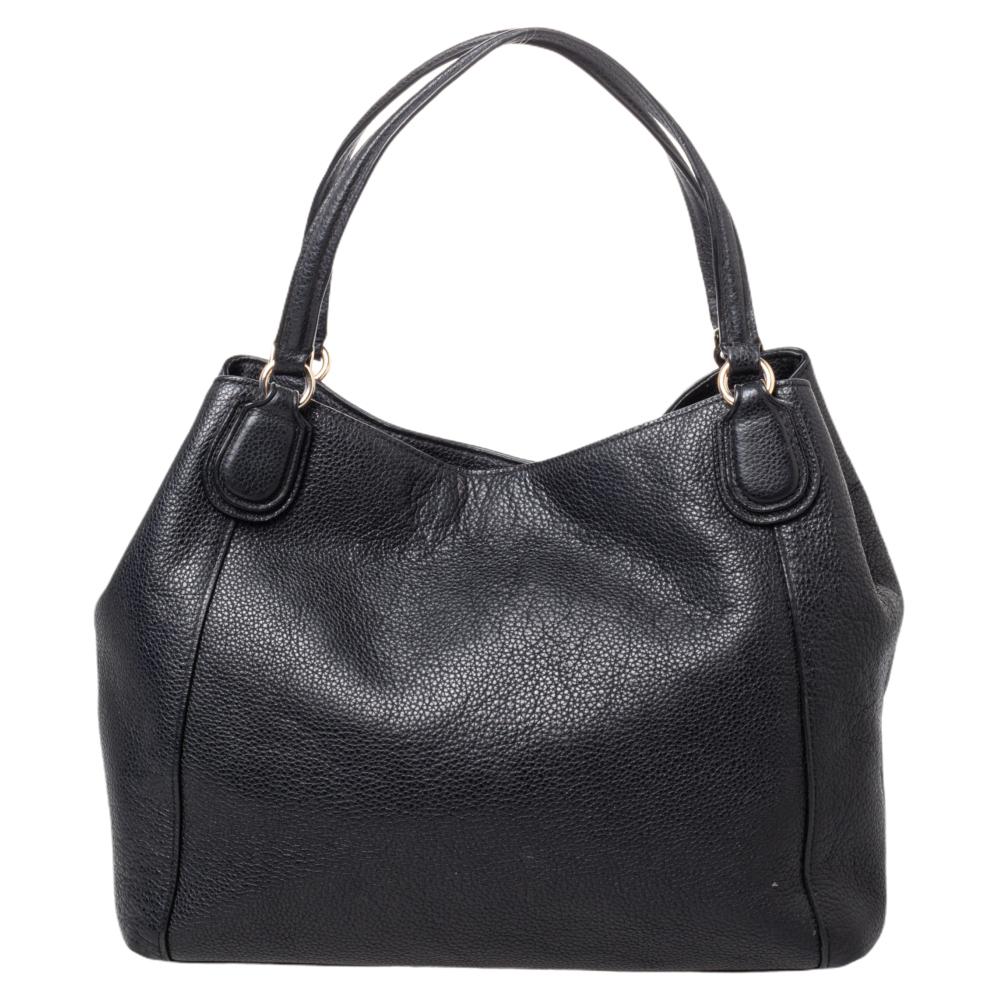 This stylish Coach shoulder bag is great for everyday use and is very functional. Crafted from quality leather, it comes in a classic shade of black. It is held by dual handles and is styled with the brand logo, spacious interior and gold-tone