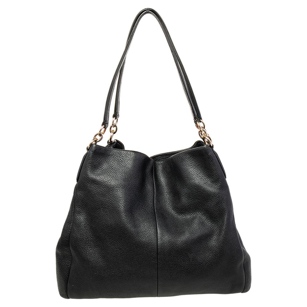 Grab this stylish shoulder bag from Coach to style your everyday looks effortlessly. Crafted from quality leather, this Edie bag comes in black. It is styled with dual handles, a nylon interior with a zip compartment, and two open compartments for