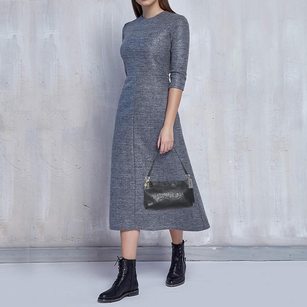 This handy bag is from the house of Coach. It has been crafted in China and made from leather with the brands signature: horse and carriage embossed on the front. It comes in a black hue and is equipped with a canvas interior that will house the