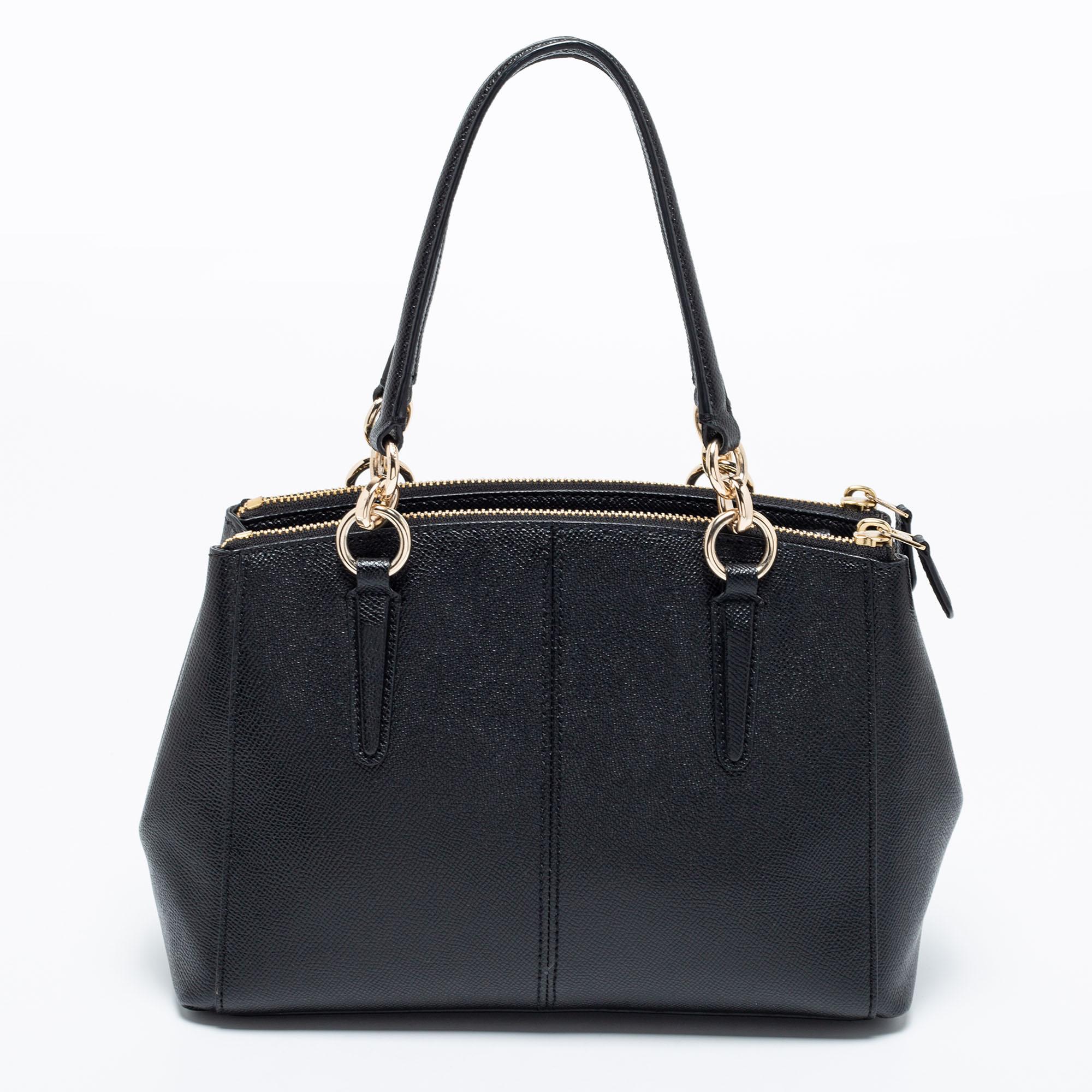 This beautiful Christie Carryall bag from Coach is highly functional and full of charm. Crafted from black leather, the bag features dual handles, a detachable shoulder strap, and brand detail on the front. The fabric-lined interior will hold all