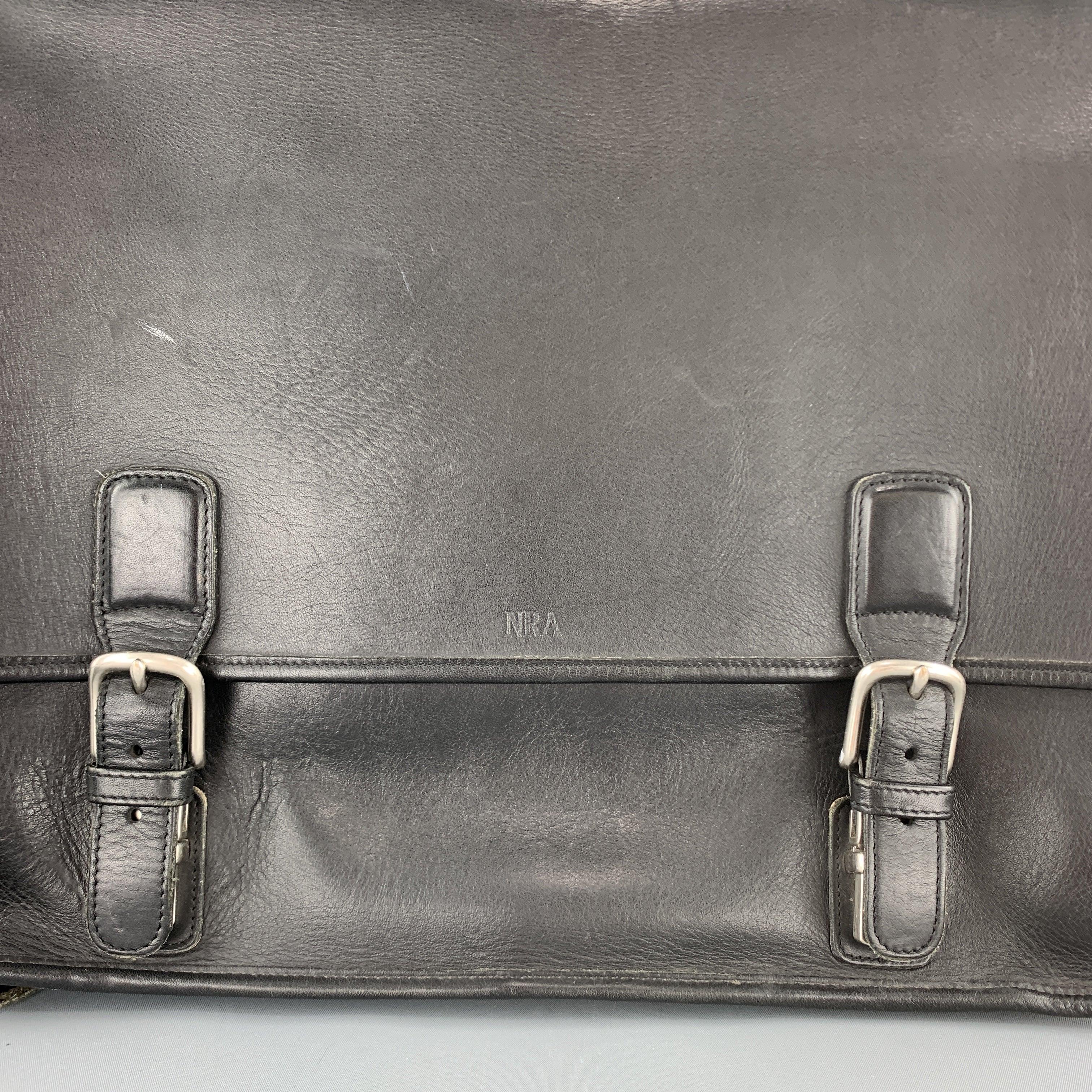 COACH briefcase comes in black leather with a top flap, double faux buckle press snap closures, internal zip compartments with detachable laptop padding, and crossbody strap. 