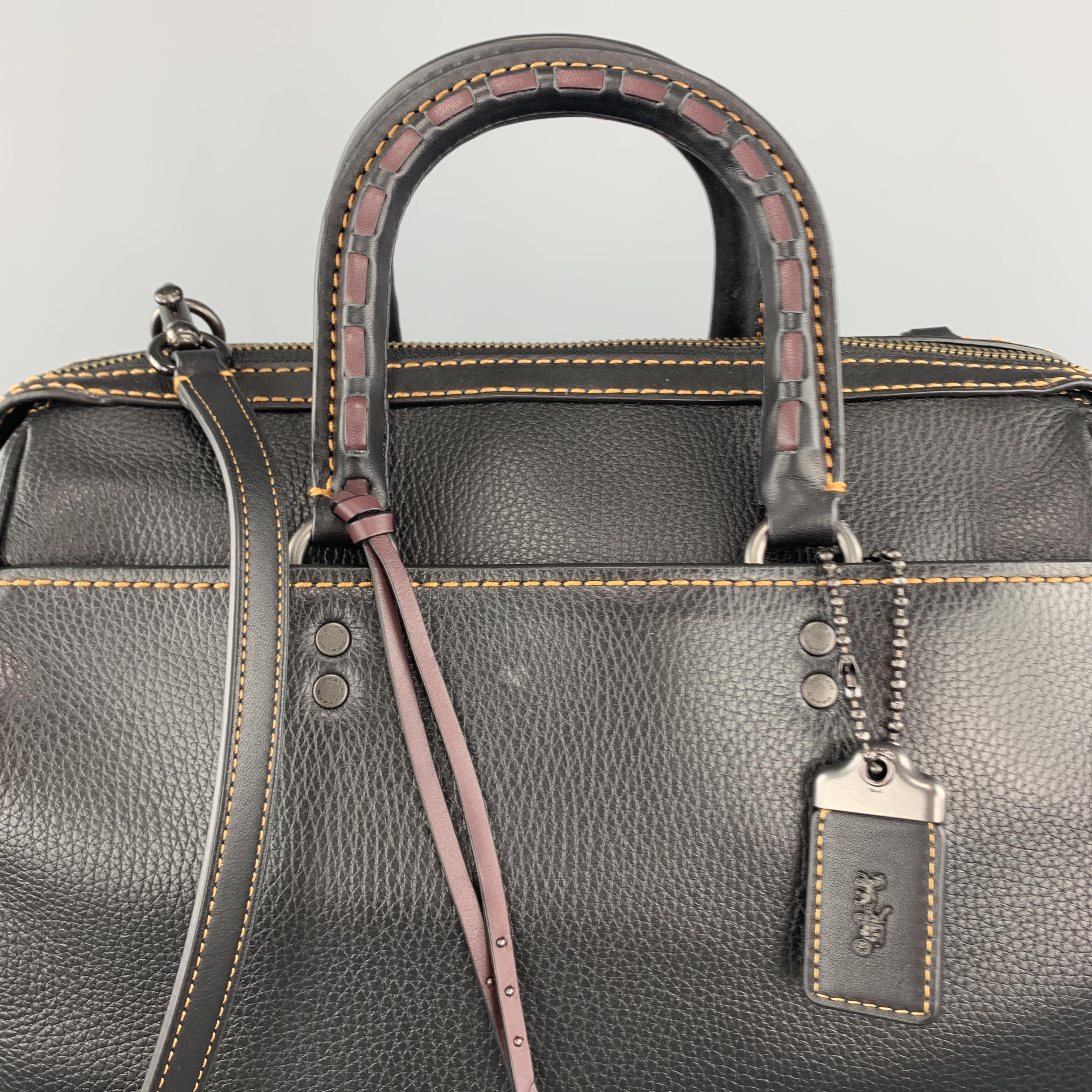 COACH handbag comes in black pebbled leather with contrast stitching, outer pockets, purple whipstich top handles, detachable strap, and suede interior. 

New without Tags.

Measurements:

Length: 12 in.
Width: 7 in.
Height: 8 in.
Drop: 19 in.