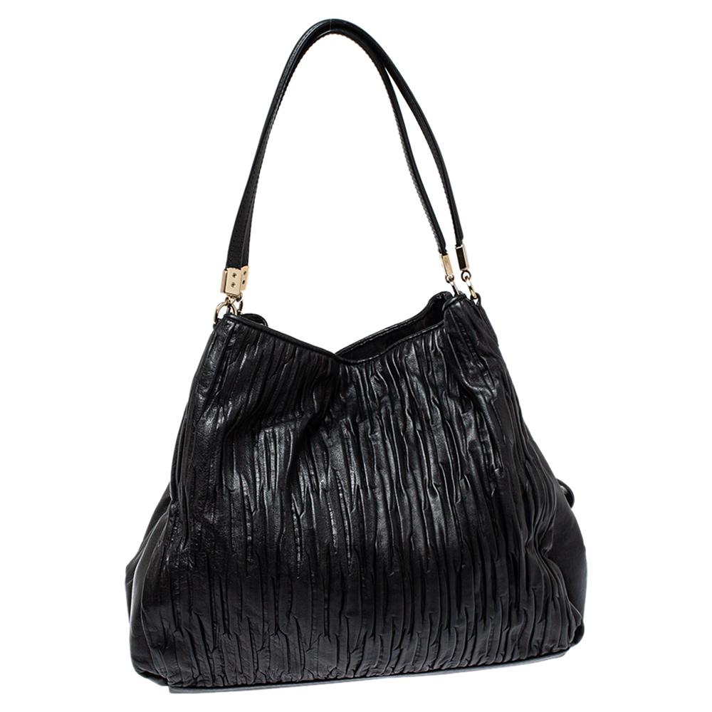 This stylish Edie 31 bag comes from the house of Coach. Crafted from pleated leather, this black bag is styled to deliver functionality and style. It comes with dual handles, a signature tag, and a satin-lined interior. It is finished with gold-tone