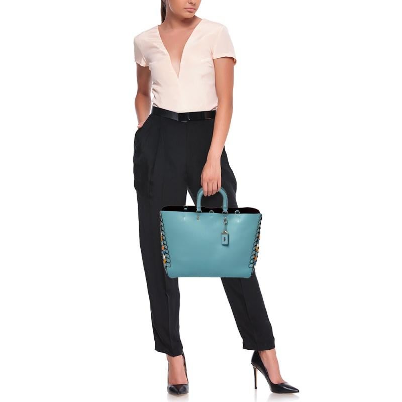 Coach’s tote is generously spaced and efficiently compartmentalized for easy organization. The creation is crafted from blue leather into a sturdy silhouette, especially for the contemporary woman. The tote is finished off with dual handles, link