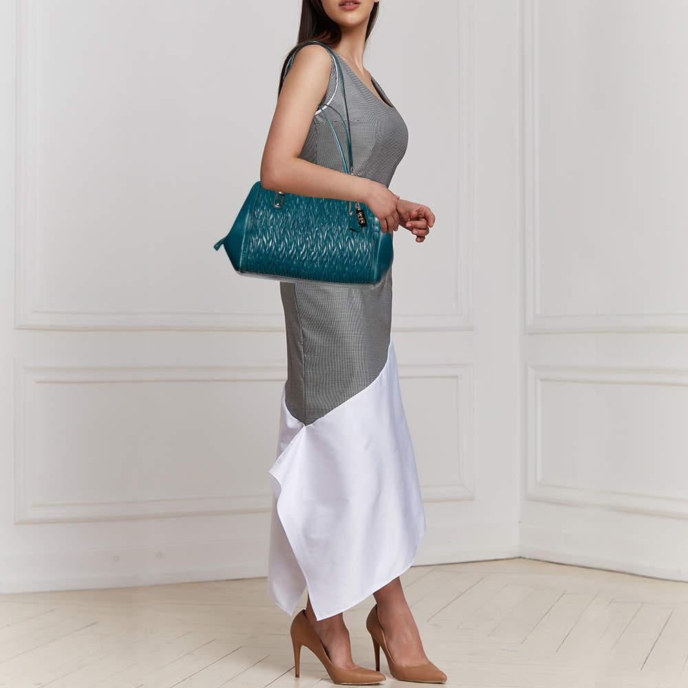 Exhibiting a contemporary design  this satchel from the house of Coach will instantly elevate your outfits. This bag is crafted from luxurious leather in a gorgeous gathered style. It comes in a lovely shade of blue and is held by dual handles. The