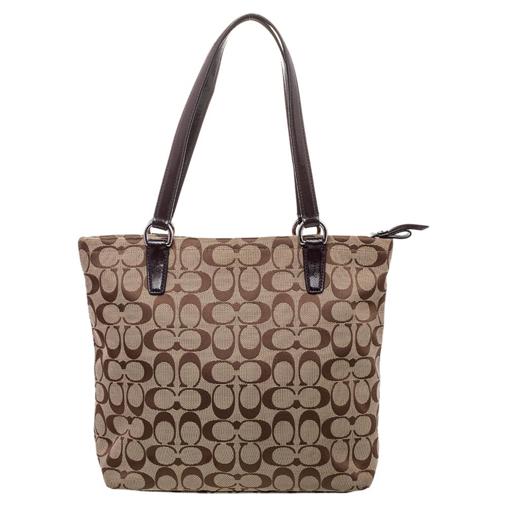 This elegant tote is from the house of Coach. Crafted from signature coated canvas and patent leather, and lined with canvas on the insides, the bag features dual top handles and silver-tone hardware. Swing it along for shopping or on lunch with
