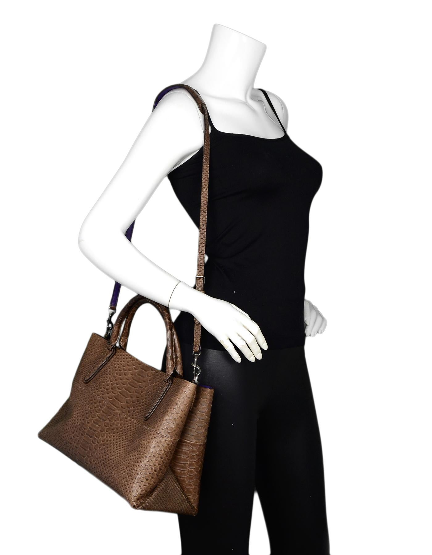 Coach Brown Leather Embossed Snakeskin Tote Bag W/ Strap

Color: Brown with purple trim
Hardware: Silvertone
Materials: Embossed snakeskin leather
Lining: Purple leather
Closure/Opening: Magnetic closure at center
Exterior Pockets: None
Interior