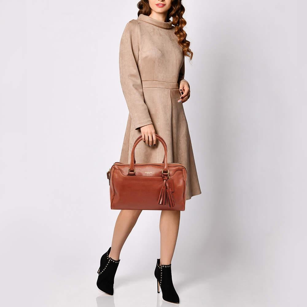 Stylish and easy to carry  this leather satchel will be a fine choice for work or after. Lined with fabric  this pre owned Coach bag can easily fit in all your essentials. It can be held in your arm or hand using the two handles.