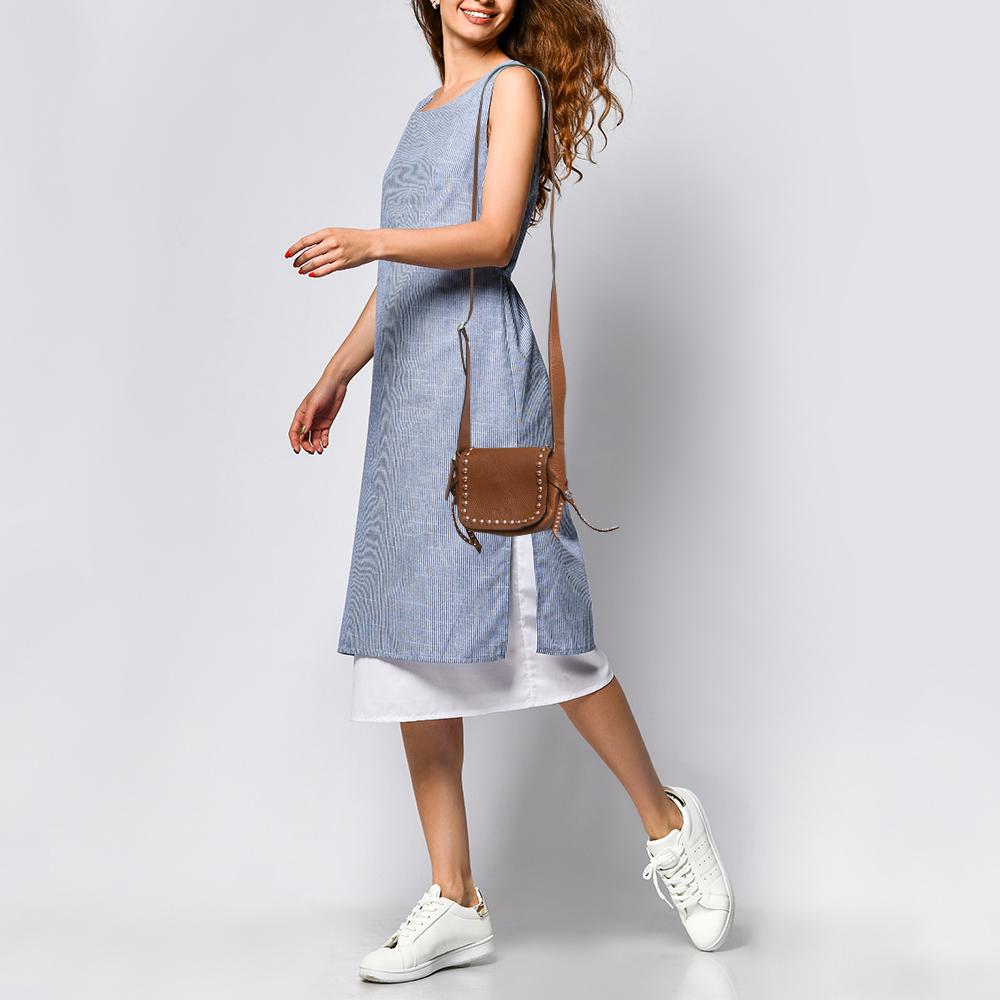 Structured, sophisticated, and stylish are some words that describe this crossbody bag! Crafted from best quality material, the creation is adorned with the label's signature appeal, held by comfortable handles, and equipped with a well-spaced