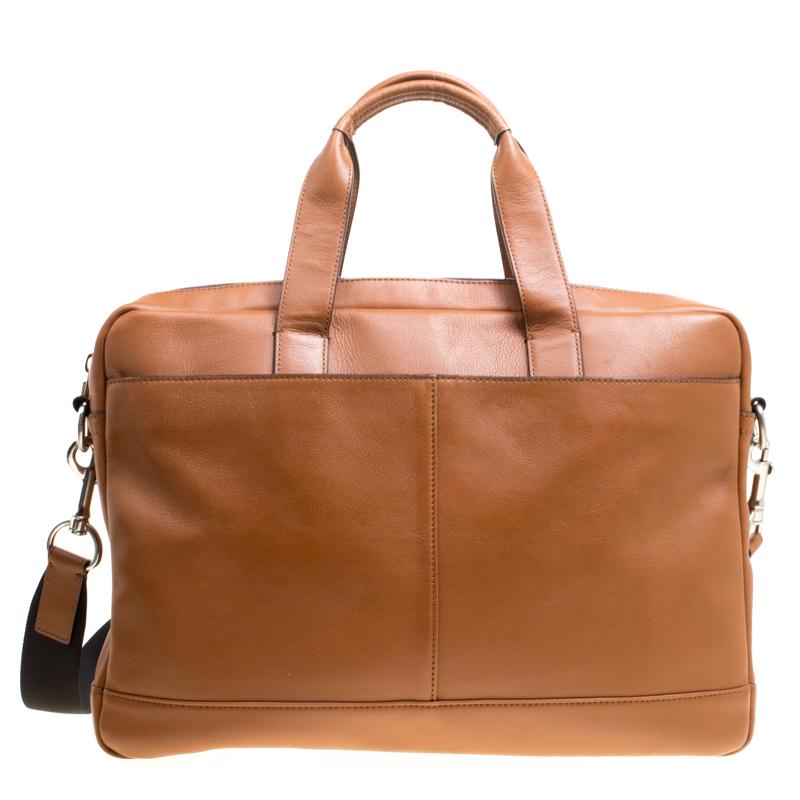 This Coach briefcase brings such a fantastic shape that you're sure to look fashionable whenever you carry it. It has been crafted from brown leather and designed with two top handles, a shoulder strap, and a zipper to secure the well-sized fabric