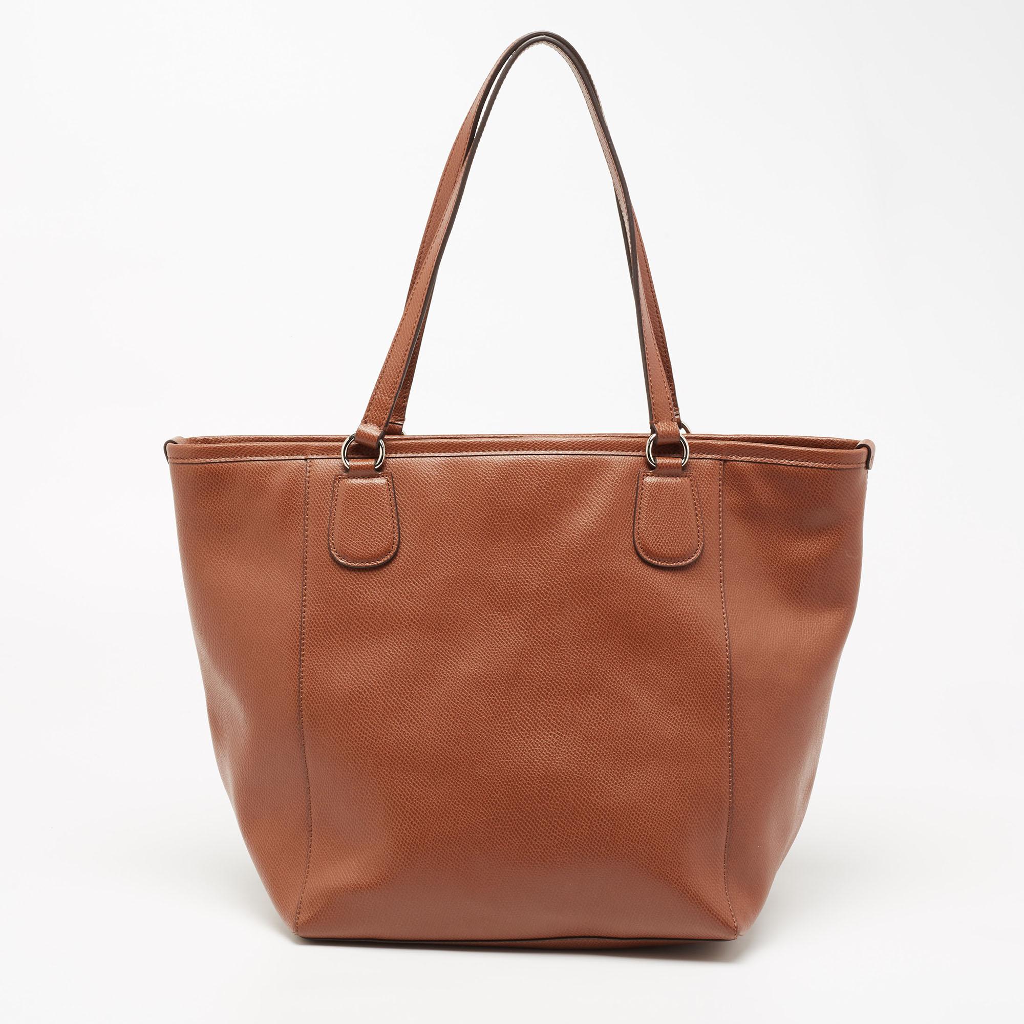 This designer tote from the House of Coach is super classy and functional, perfect for everyday use. It is made from leather and the exterior has a front zip pocket. It has two shoulder handles.

