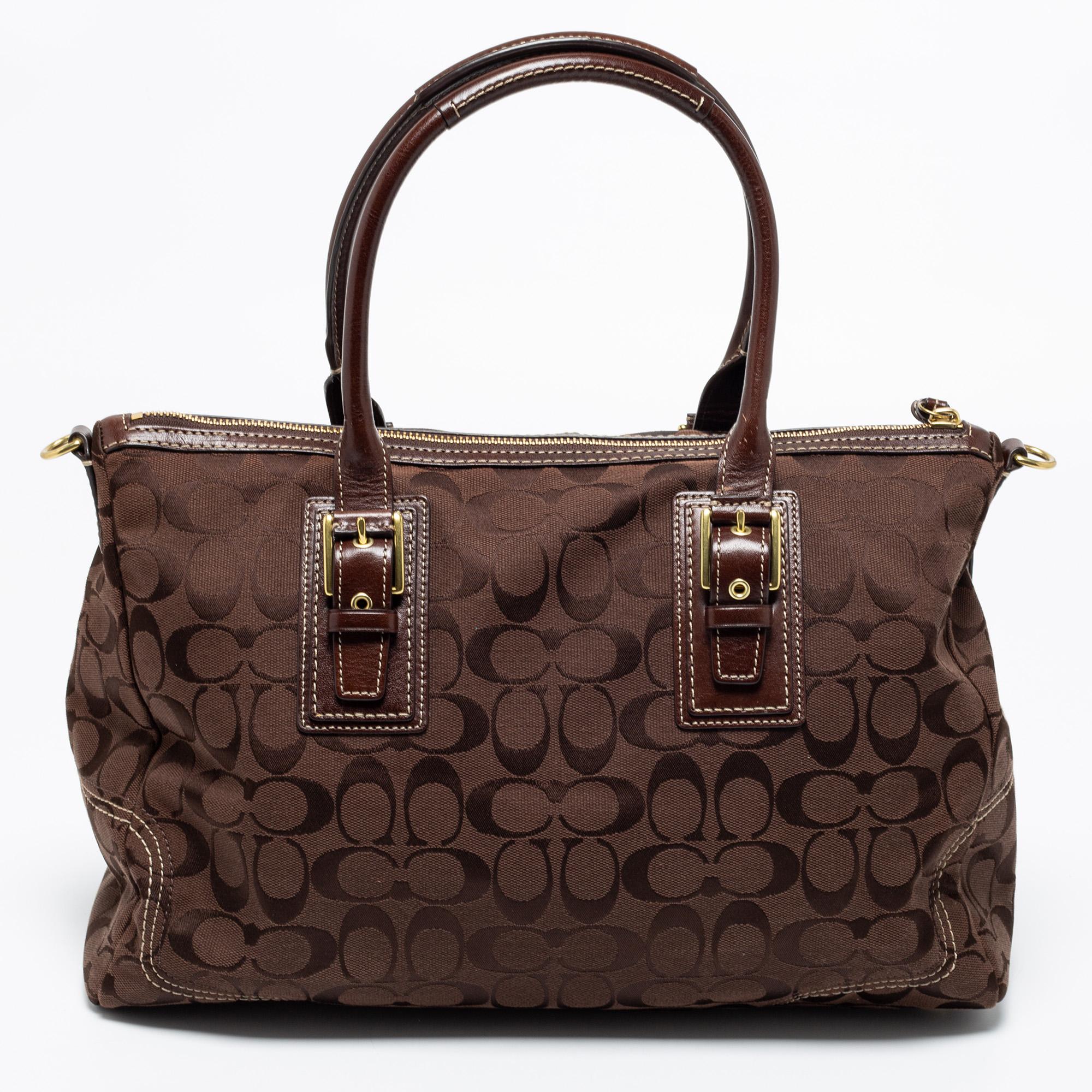 This beautiful bag from Coach is highly functional and full of charm. Crafted from signature coated canvas and leather, the brown bag features dual handles, a shoulder strap, and gold-tone hardware. The fabric-lined interior will hold all your