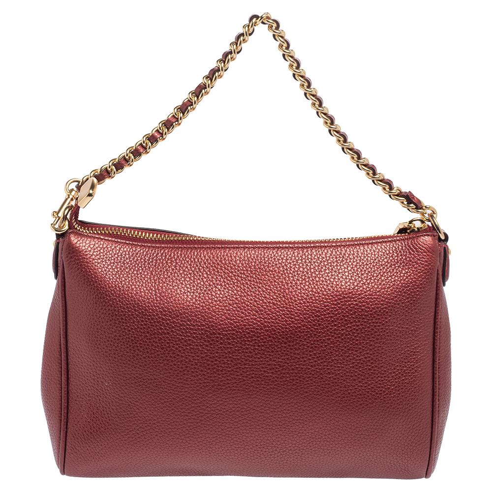 Step out in style by adorning this crossbody bag from Coach. It has been crafted from burgundy leather and flaunts the brand logo on the front. The bag features a fabric interior and is complete with a chain-link and an adjustable shoulder strap.

