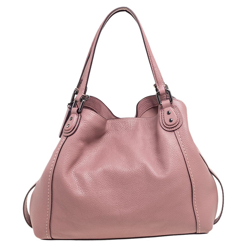 From the House of Coach, this Edie satchel is made to grant you charm and poise! It is made from burnt-pink leather on the exterior and comes with a gunmetal-toned logo on the front. It has dual handles and a spacious fabric-lined interior. Keep