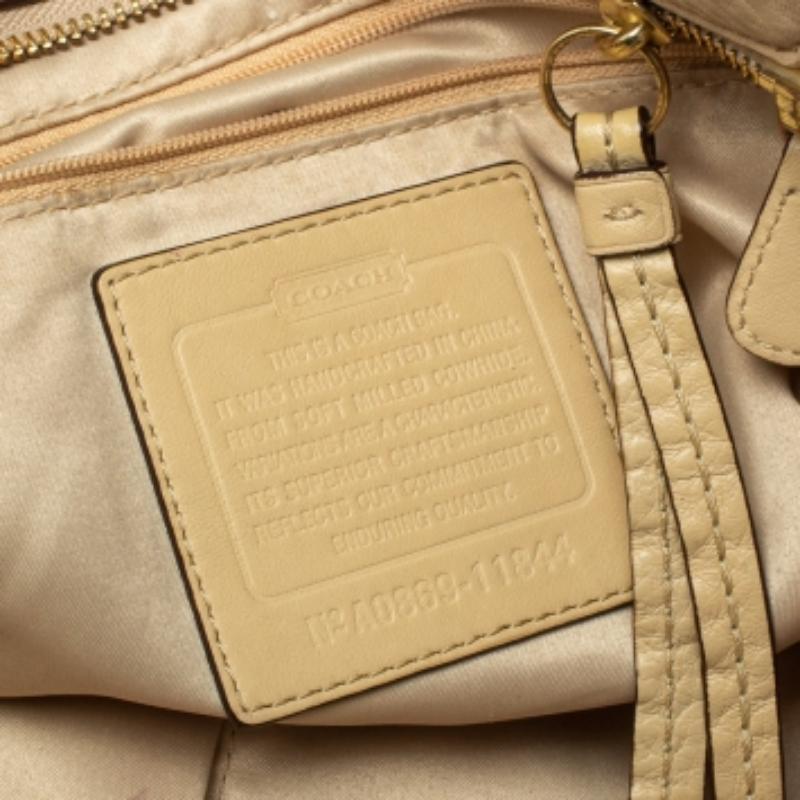 Masterfully created, this Soho tote by Coach is a style icon you cannot do without. Crafted from leather in a cream shade, the bag is equipped with a spacious interior for your daily essentials. It suspends from dual handles adorned with gold-tone