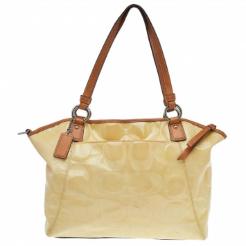 Beautifully crafted, this Coach satchel is stylish and functional. It has been crafted from embossed patent leather and equipped with a fabric interior and two handles.