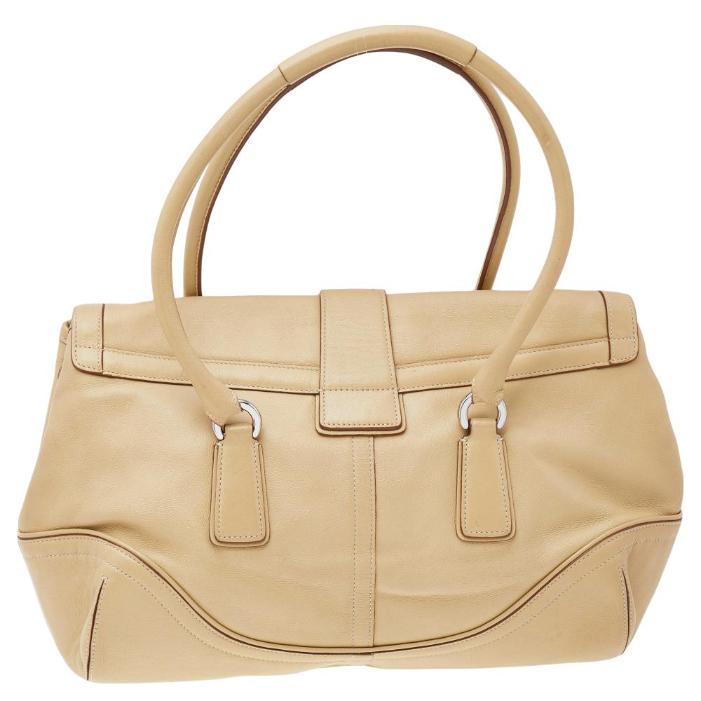 Step out in style with this Hampton satchel from Coach. It is crafted from quality leather and comes in a lovely shade of cream. The bag features dual handles and a fabric-lined interior that houses a zip pocket. This creation is finished with