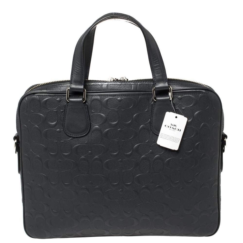 Crafted from signature leather, this dark blue Hudson 5 laptop bag by Coach features two top handles and a detachable shoulder strap. It has a front zip pocket and the nylon-lined interior is perfectly sized to carry your laptop and other