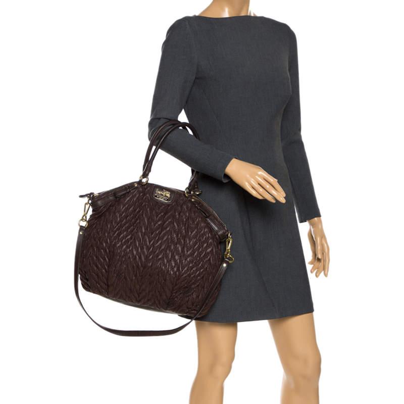 Fabulous and stylish, this Madison bag from Coach is here to charm one an all! The dark brown creation is crafted from leather and features quilt detailing. It flaunts dual top handles, a shoulder strap and the brand logo on the front. It has a