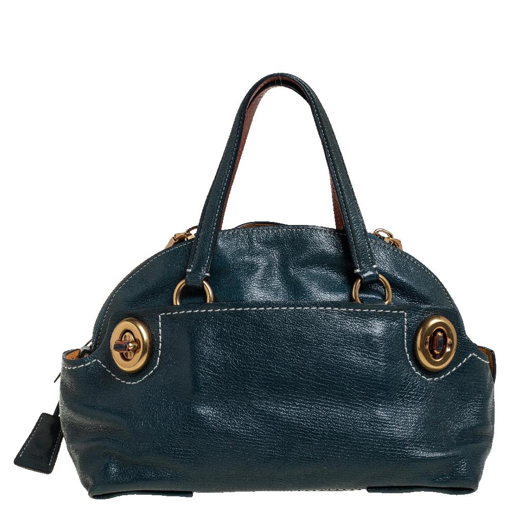 Make a wonderful appearance by adorning this plush patent leather bag. Lined with suede on the inside, it keeps all your essentials intact. This stylish satchel from Coach is held by two handles and accompanied by signature tags, turn-lock detailing