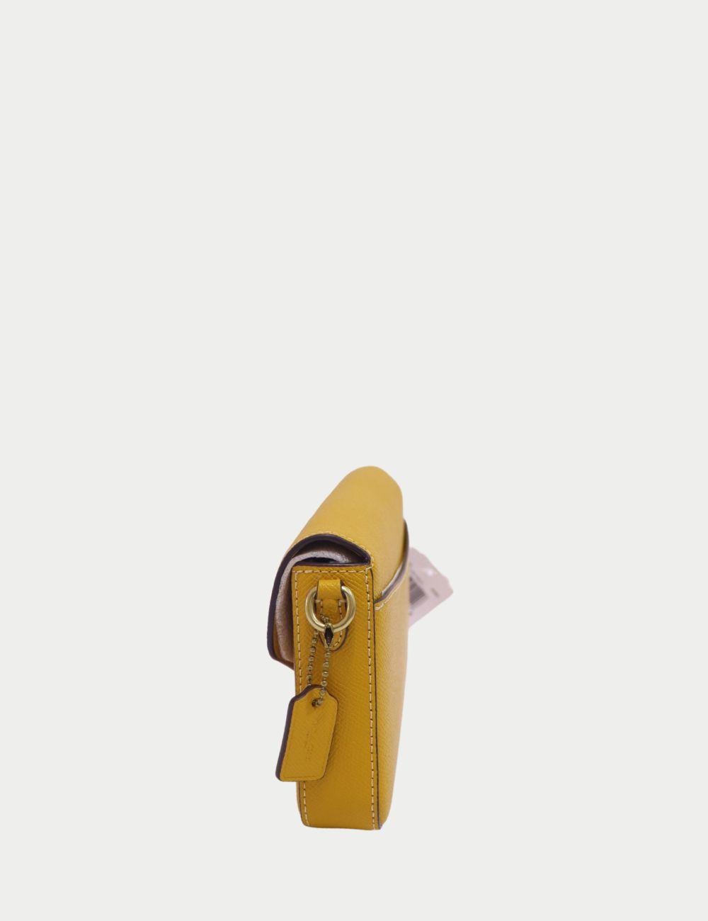 Verleihen Sie Ihrer Garderobe einen Hauch von Sonnenschein mit dieser gelben Coach Crossbody Bag. Diese elegante Tasche aus strapazierfähigem, gekörntem Leder zeichnet sich durch eine strukturierte Silhouette und einen Überschlag mit dem