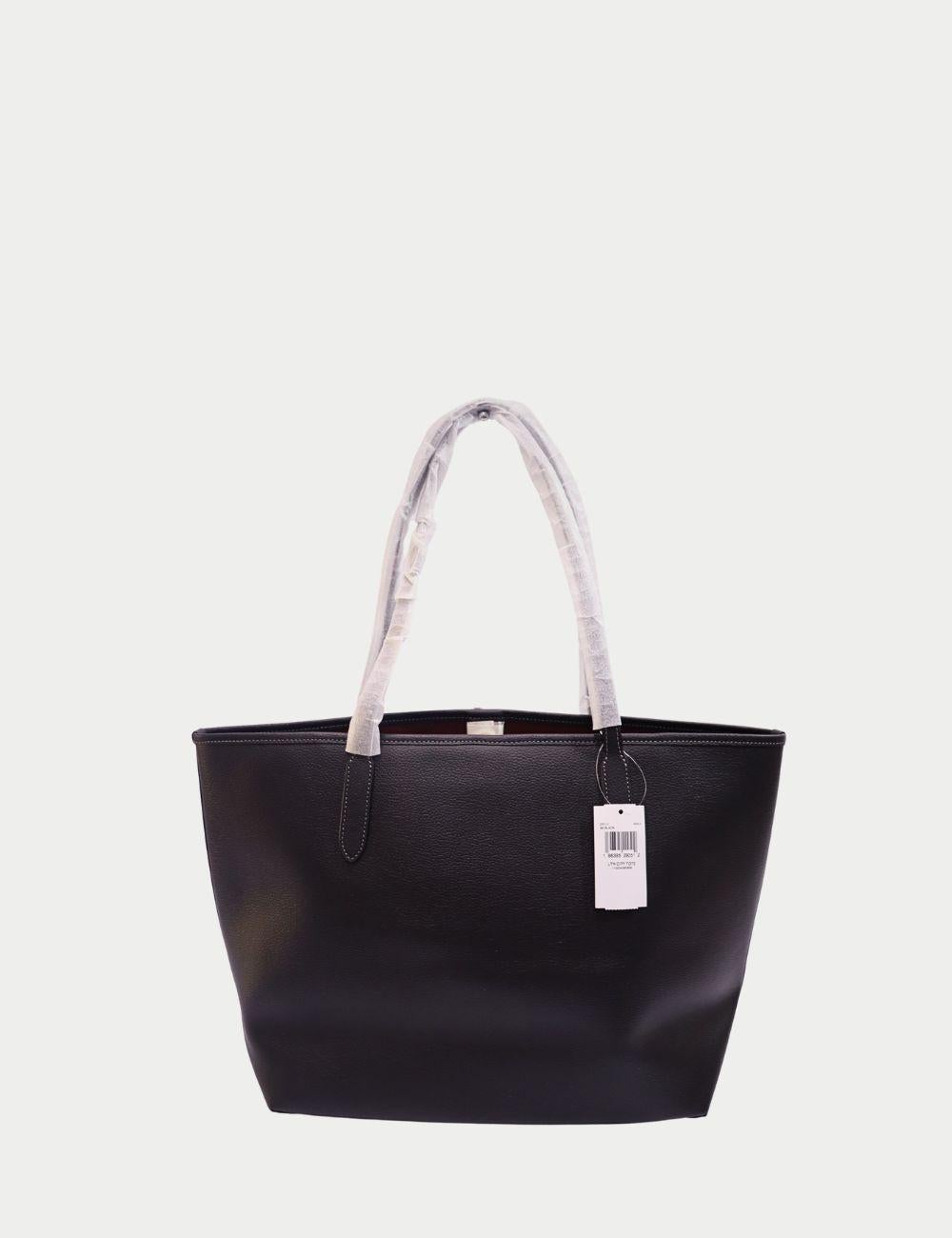 Lleva el lujo a diario con este Bolso Tote Coach de piel granulada negra, diseñado pensando tanto en el estilo como en la practicidad. Fabricado en resistente piel granulada, este bolso tote presenta una silueta elegante acentuada con el logotipo de