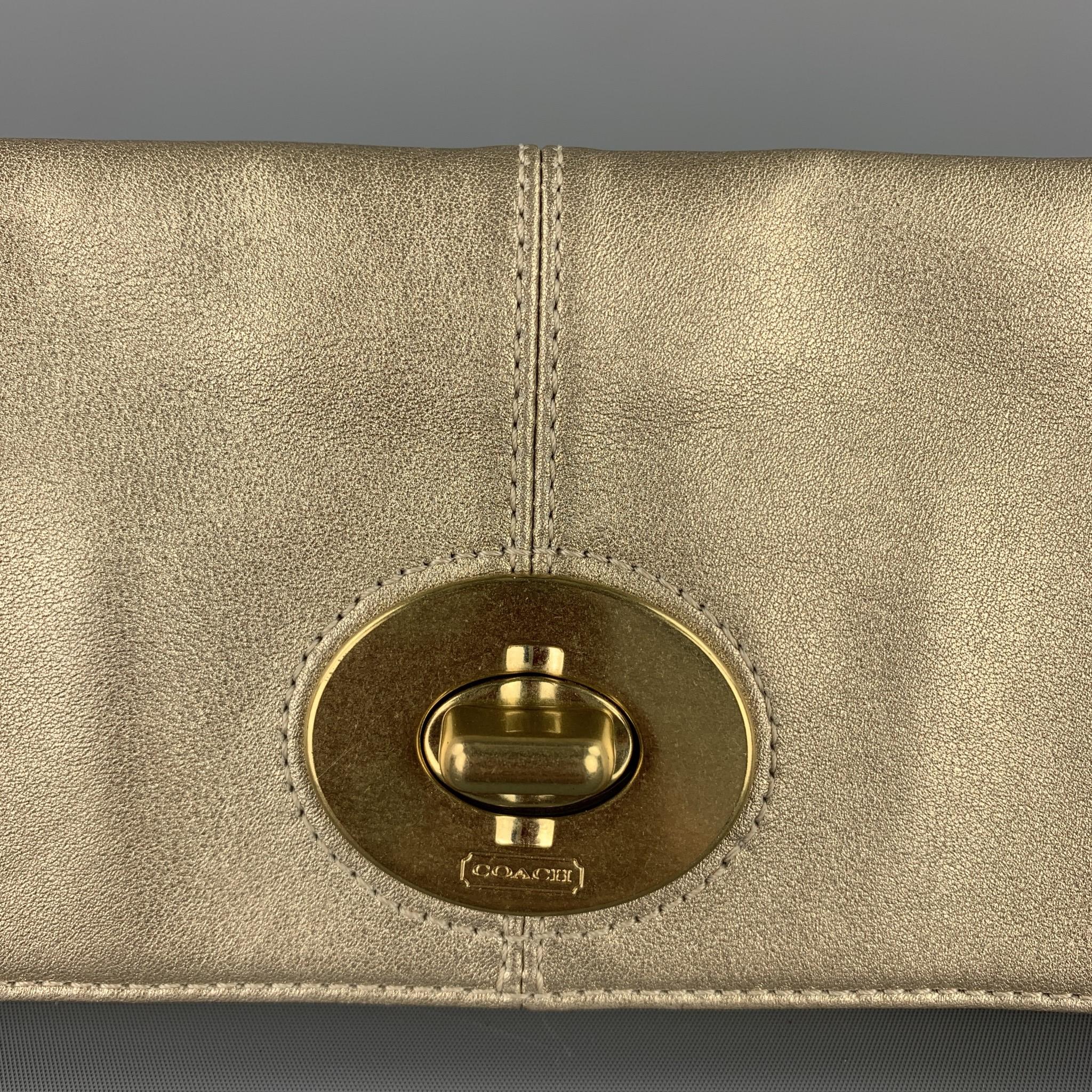 COACH purse comes in a gold leather featuring a clutch style, gold tone hardware, zipper pocket, and a clasp closure.

Good Pre-Owned Condition.

Measurements:

Length: 10 in. 
Width: 0.5 in. 
Height: 8 in. 