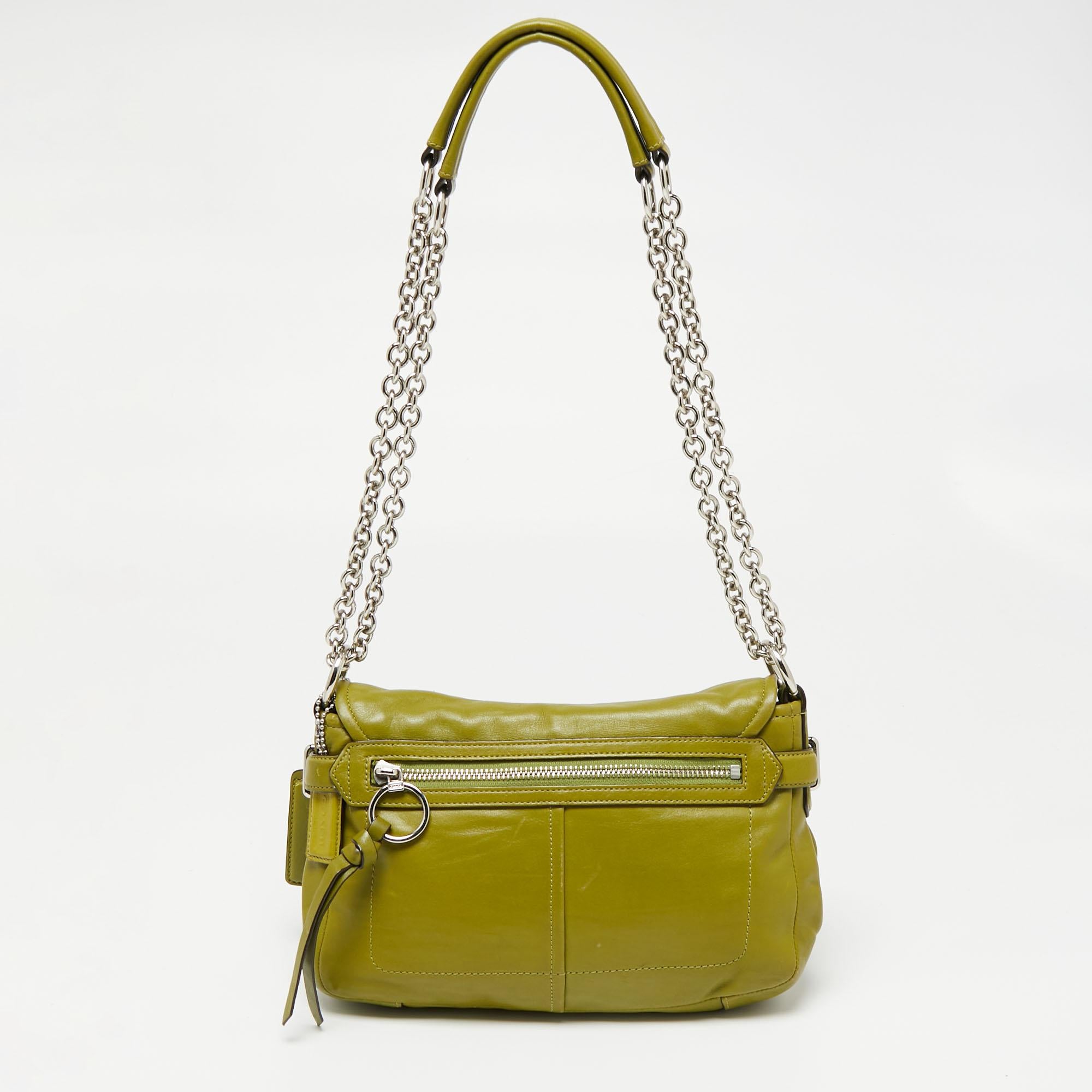 This functional flap bag by Coach is crafted from green leather. It comes with a sliding shoulder handle and a satin-lined interior. The bag is highlighted by a silver-tone lock on the flap.

Includes: Info Card
