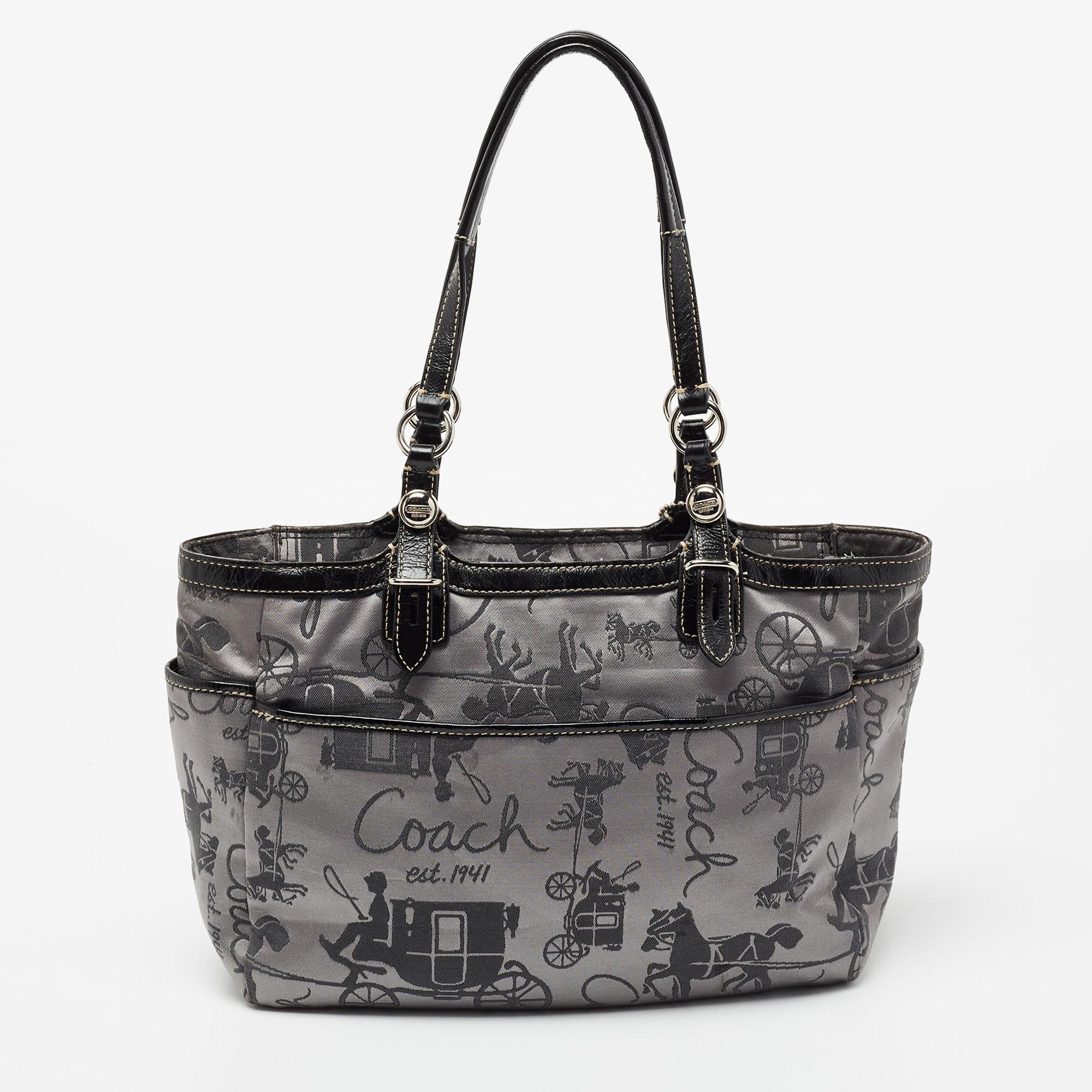 Crafted from printed fabric and leather, this Coach tote is stylish and functional. It carries a grey-black exterior and a top zipper that leads way to a satin interior well-sized to carry your essentials. The artistic bag is equipped with two