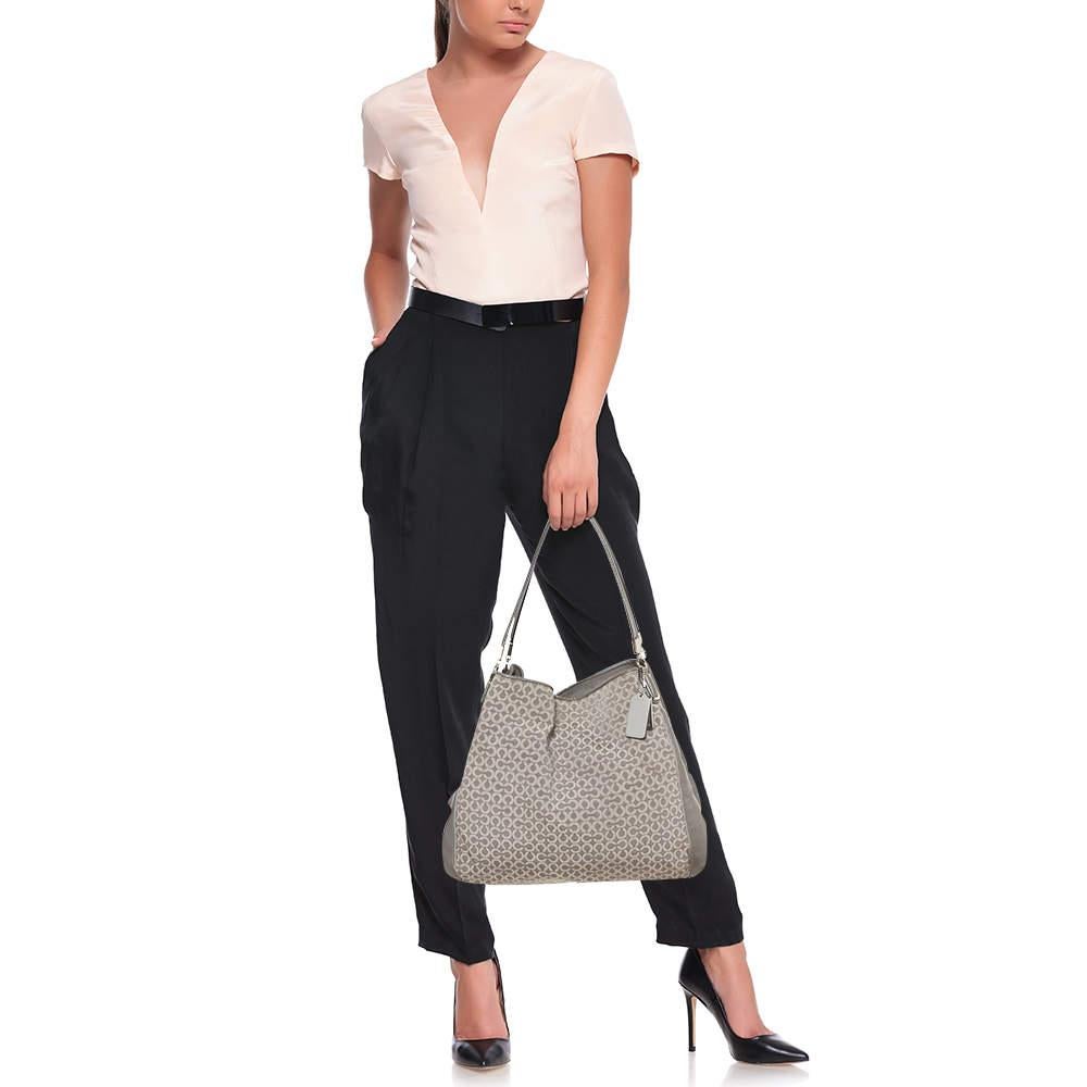 This stylish Edie 31 bag comes from the house of Coach. Crafted from signature coated canvas and leather, this grey bag is styled to deliver functionality and style. It comes with dual handles, a signature tag, and a satin-lined interior. It is