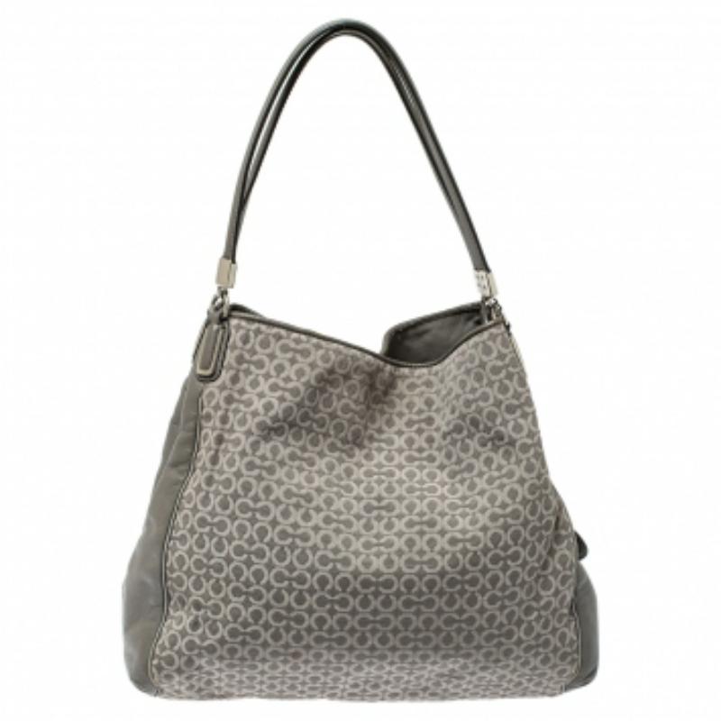 This stylish Edie 31 bag comes from the house of Coach. Crafted from signature coated canvas and leather, this grey bag is styled to deliver functionality and style. It comes with dual handles, a signature tag, and a satin-lined interior. It is