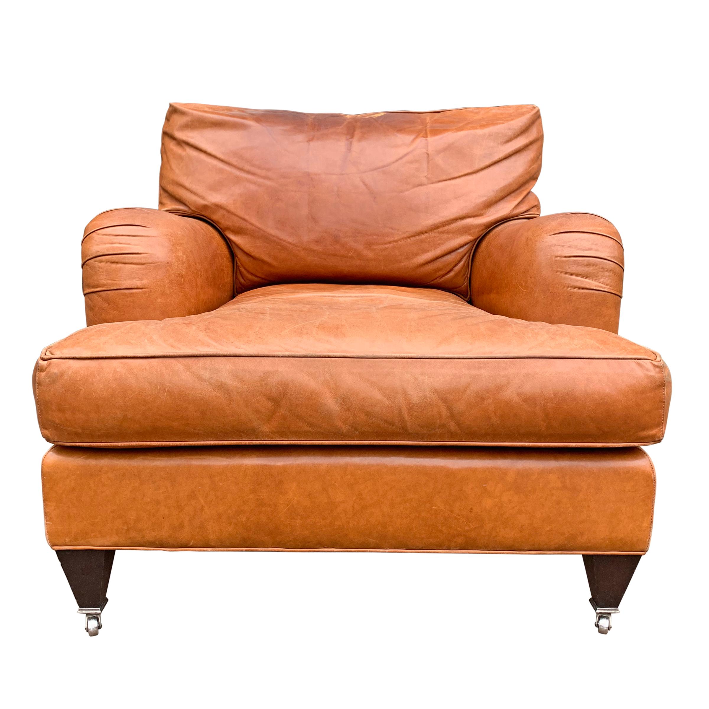 A crazy comfortable English roll armchair upholstered in a super soft coach leather with a down filled back cushion and a down wrapped foam seat cushion, with short tapered square legs ending in casters on the front.