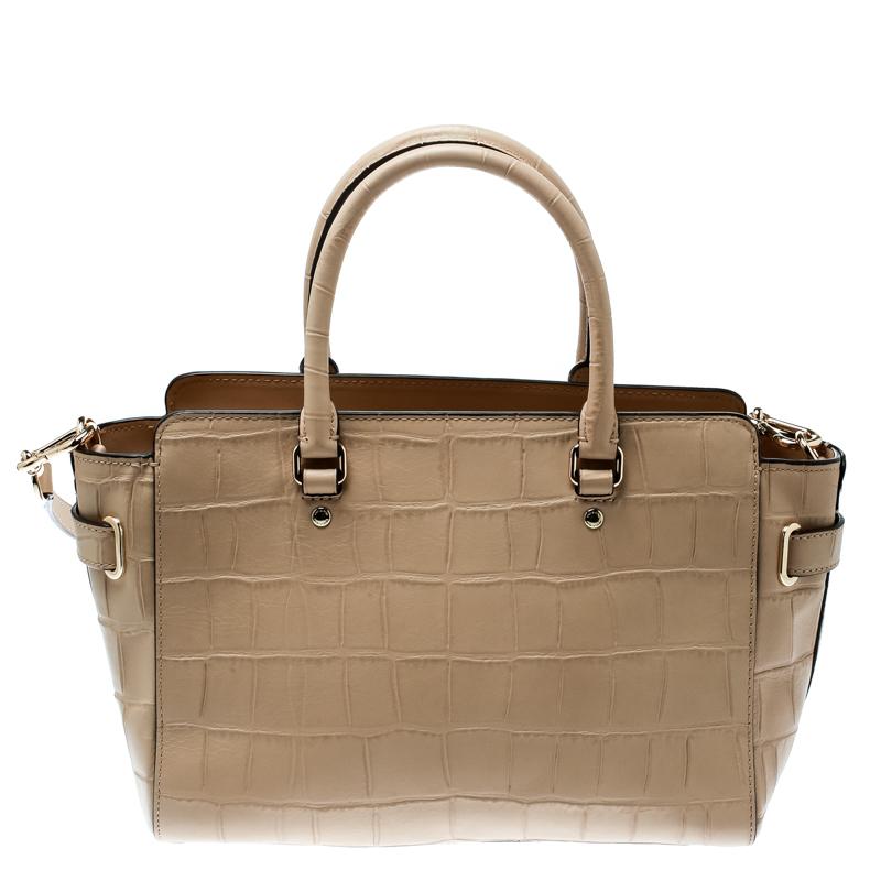 Crafted from croc-embossed leather, this Coach Carryall is stylish and functional. It carries a light brown exterior, gold-tone hardware and a fabric interior. The satchel is equipped with two handles, a removable shoulder strap and is complete with