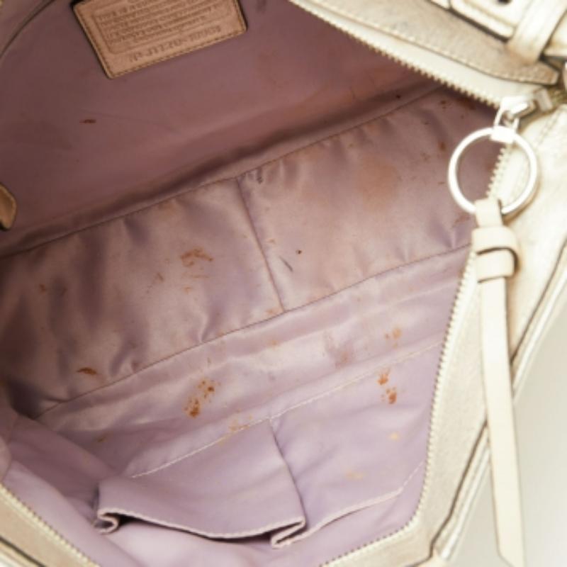 Una bonita pieza de diseño es este bolso bandolera para llevar tus imprescindibles esta temporada. Diseñado por Coach, el bolso dorado claro está fabricado en piel con herrajes plateados. Presenta un interior espacioso, detalles de cuerda lateral y