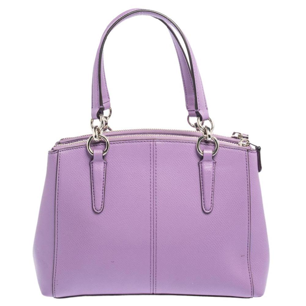 This beautiful Christie Carryall bag from Coach is highly functional and full of charm. Crafted from purple leather, the bag features dual handles, a detachable shoulder strap, and brand detail on the front. The nylon-lined interior will hold all