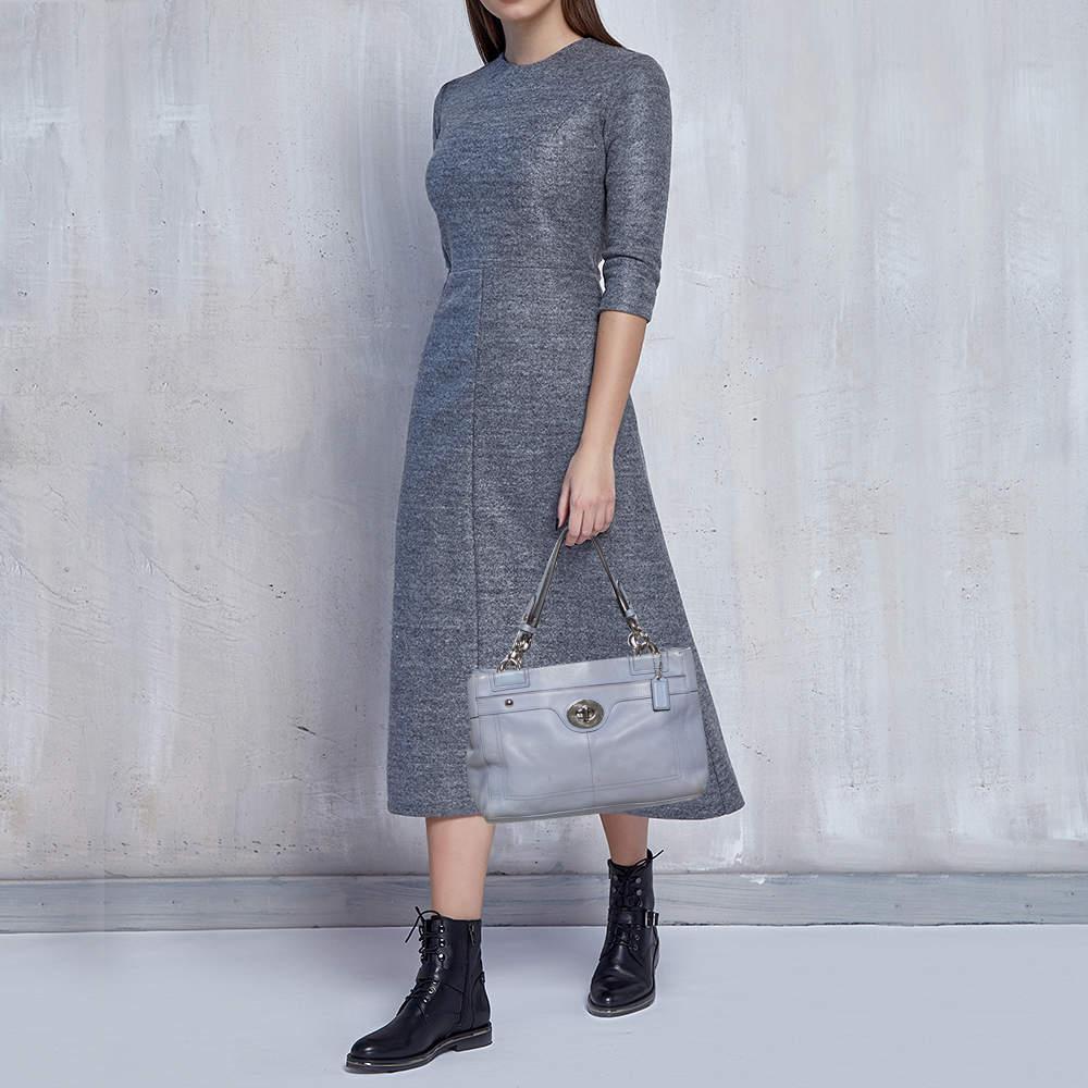 This elegant Penelope tote from Coach is crafted from lilac leather. It features the twist lock detail on the front dual top handles and silver tone hardware. The spacious interior can carry all your daily necessities.