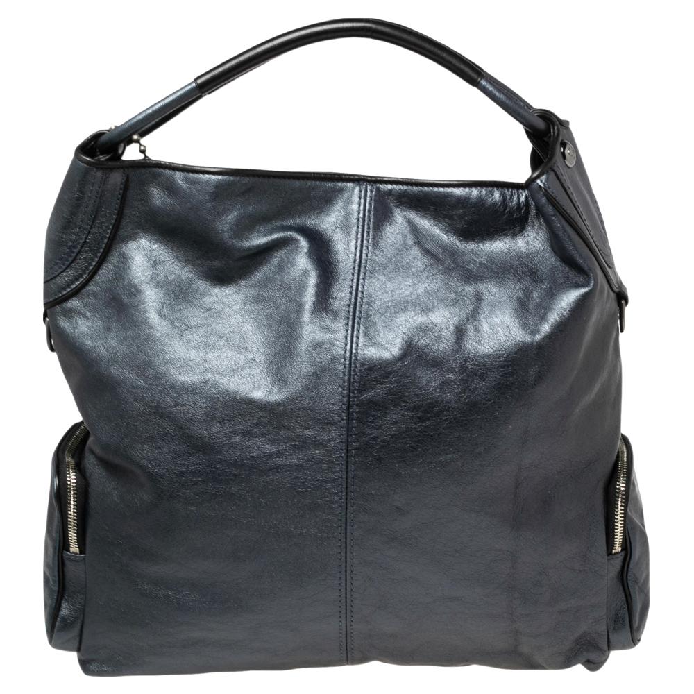 Give your bag collection the right addition with this Coach hobo that comes in a shade of metallic blue. Masterfully crafted from leather, this bag can easily hold more than just essentials. It comes with a single handle, pockets on the front, and