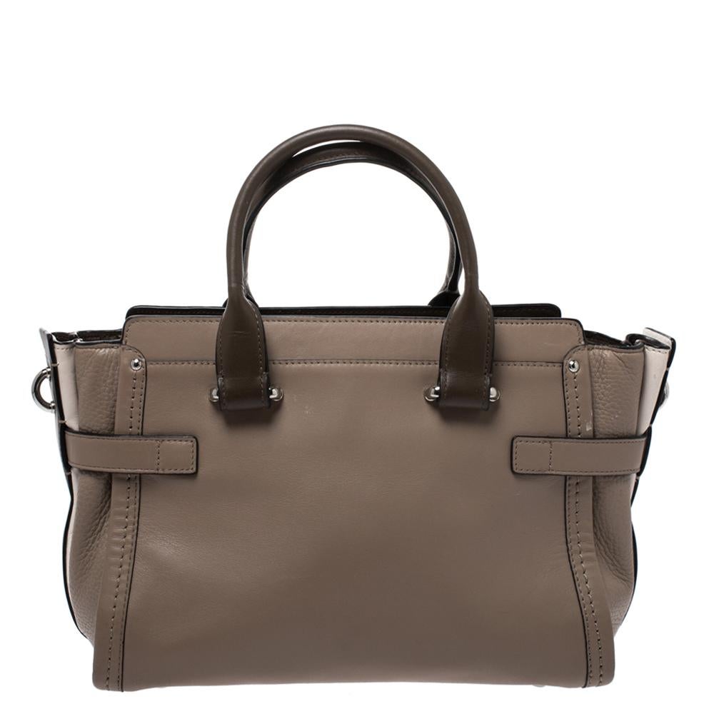 Crafted from leather, this Coach Swagger bag is stylish and functional. It carries a multicolor exterior and a top zipper that leads way to a nylon compartment sized to carry your essentials. The bag is equipped with two handles, a removable